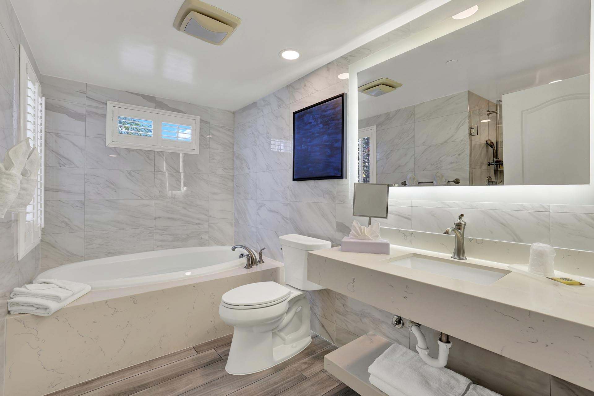 A bathroom with a sink, tub, and toilet