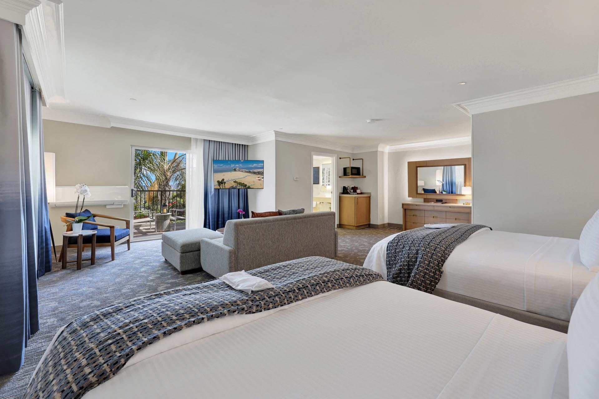 A spacious suite with two queen beds and a seating area