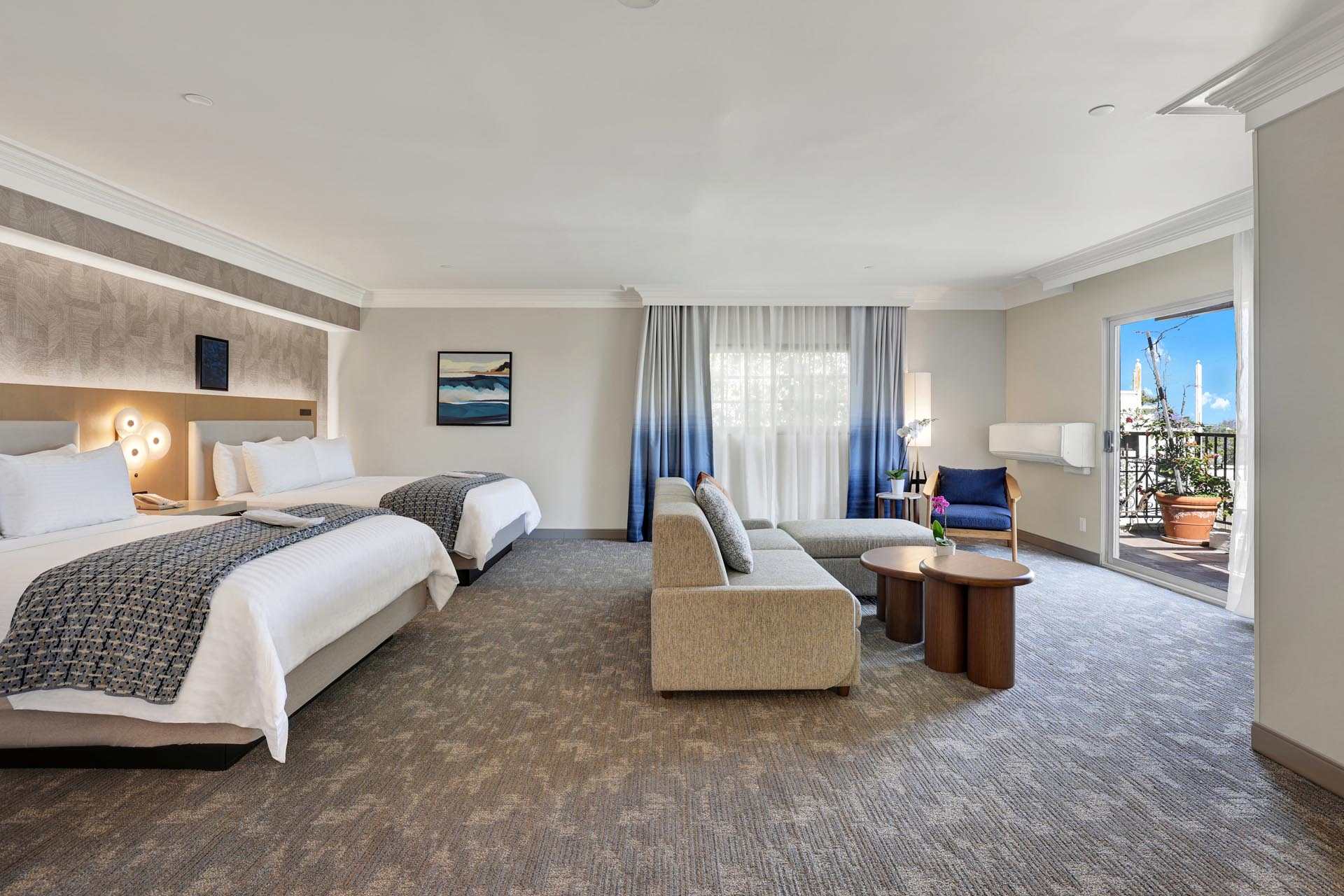 A suite with two queen beds and a seating area