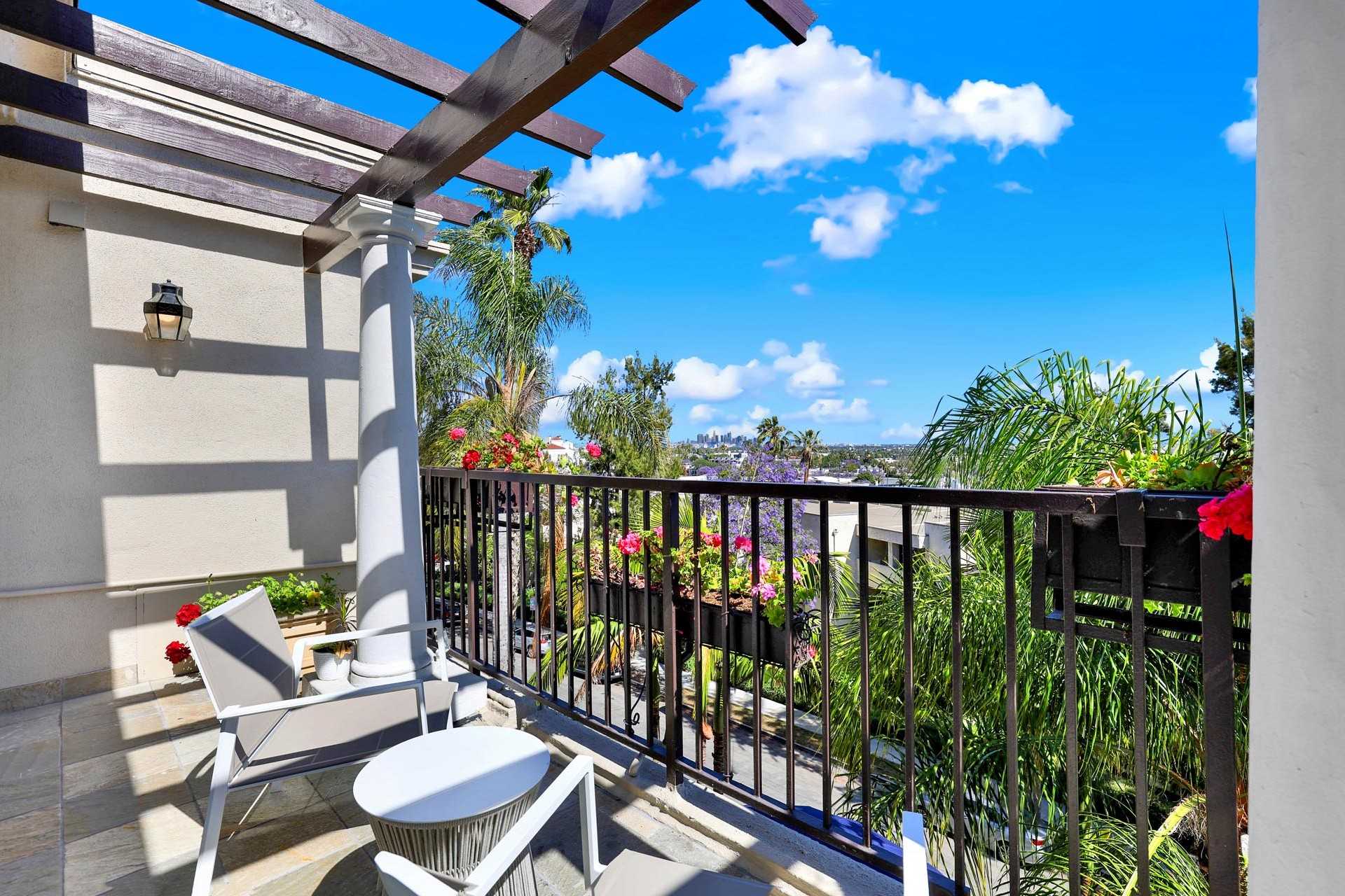 A balcony with seating and views of the city