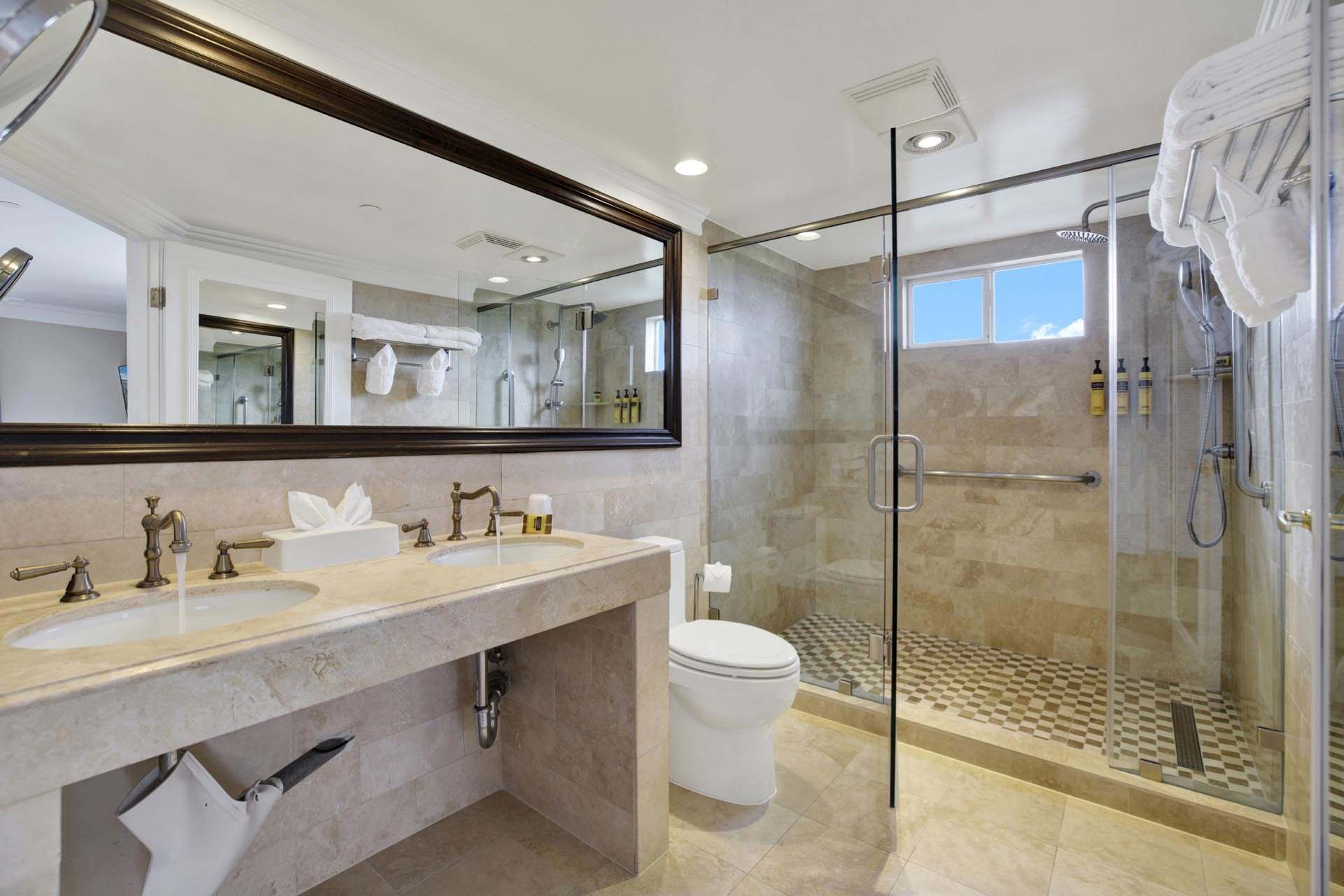 A bathroom with a double sink and a walk-in shower