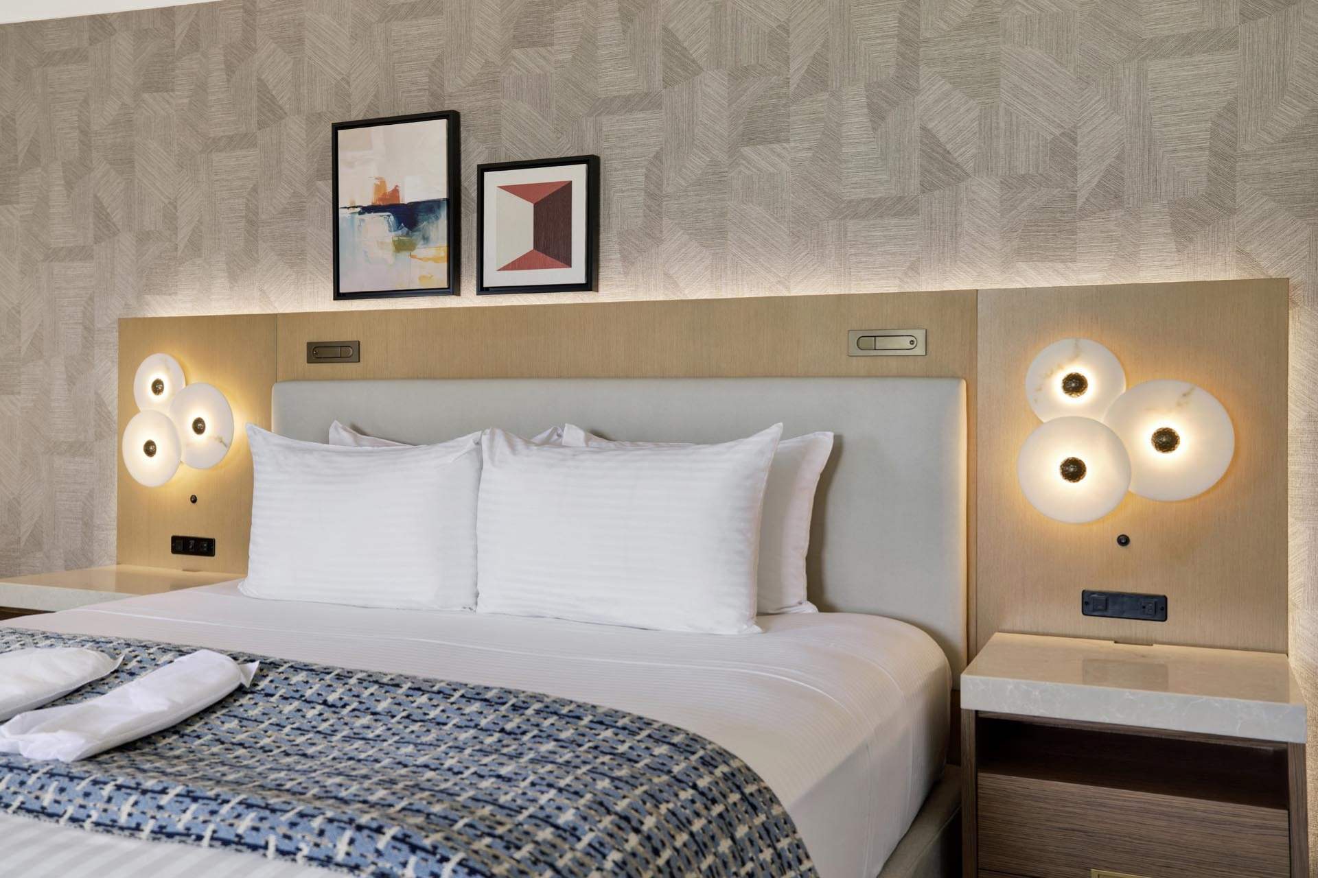 A king bed with two pillows and white and blue linens