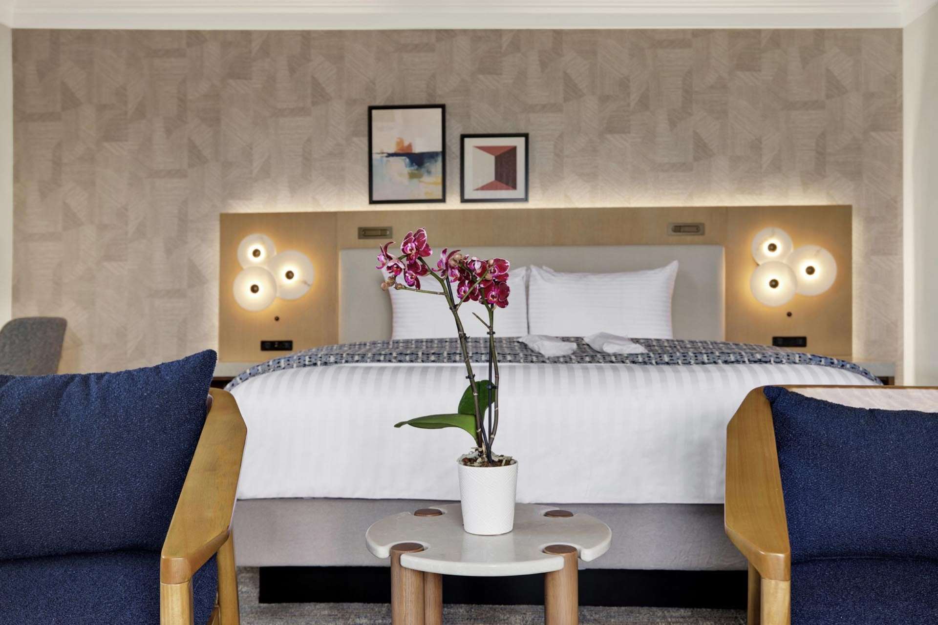 Two armchairs in front of a king bed