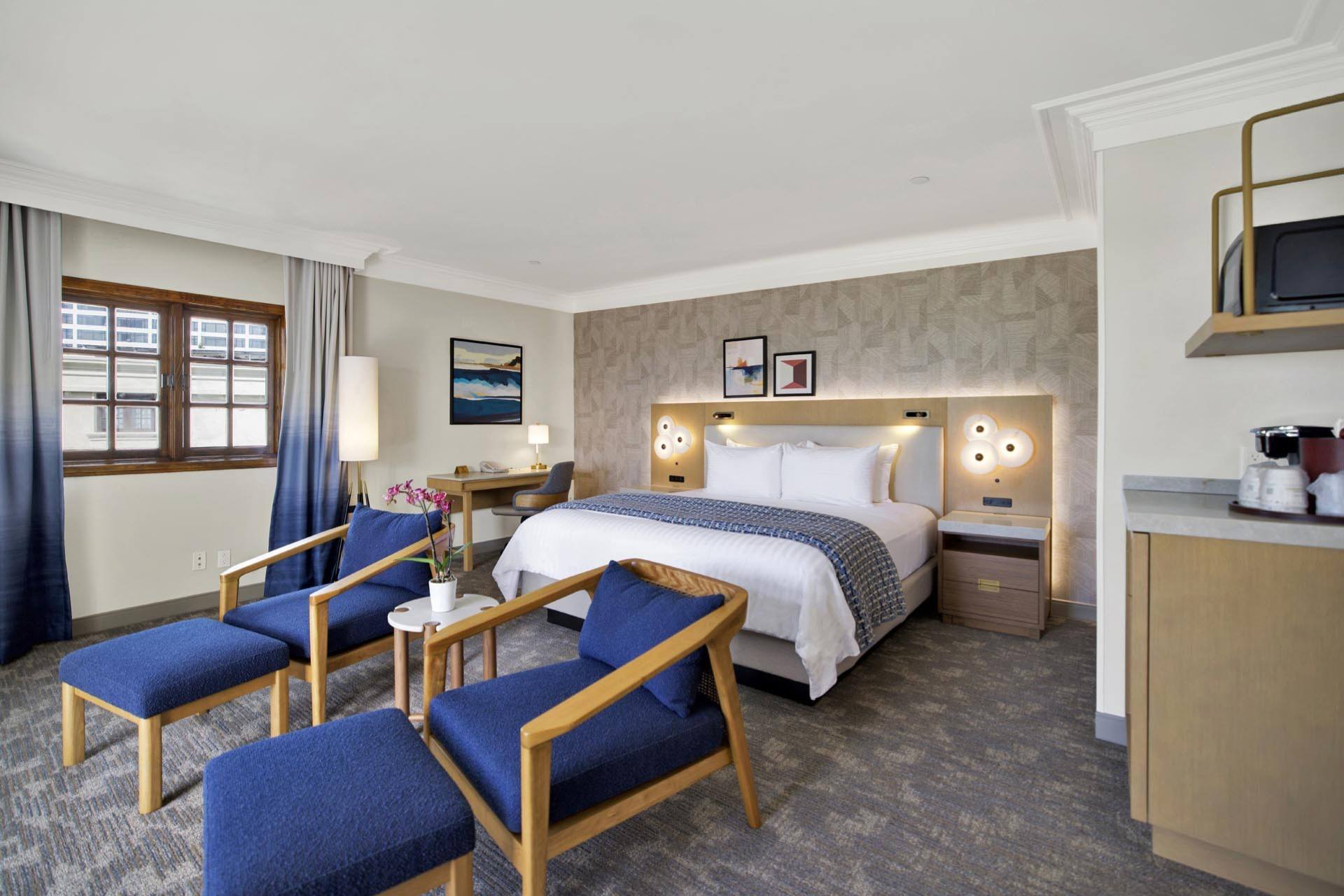 A suite with a king bed and two armchairs