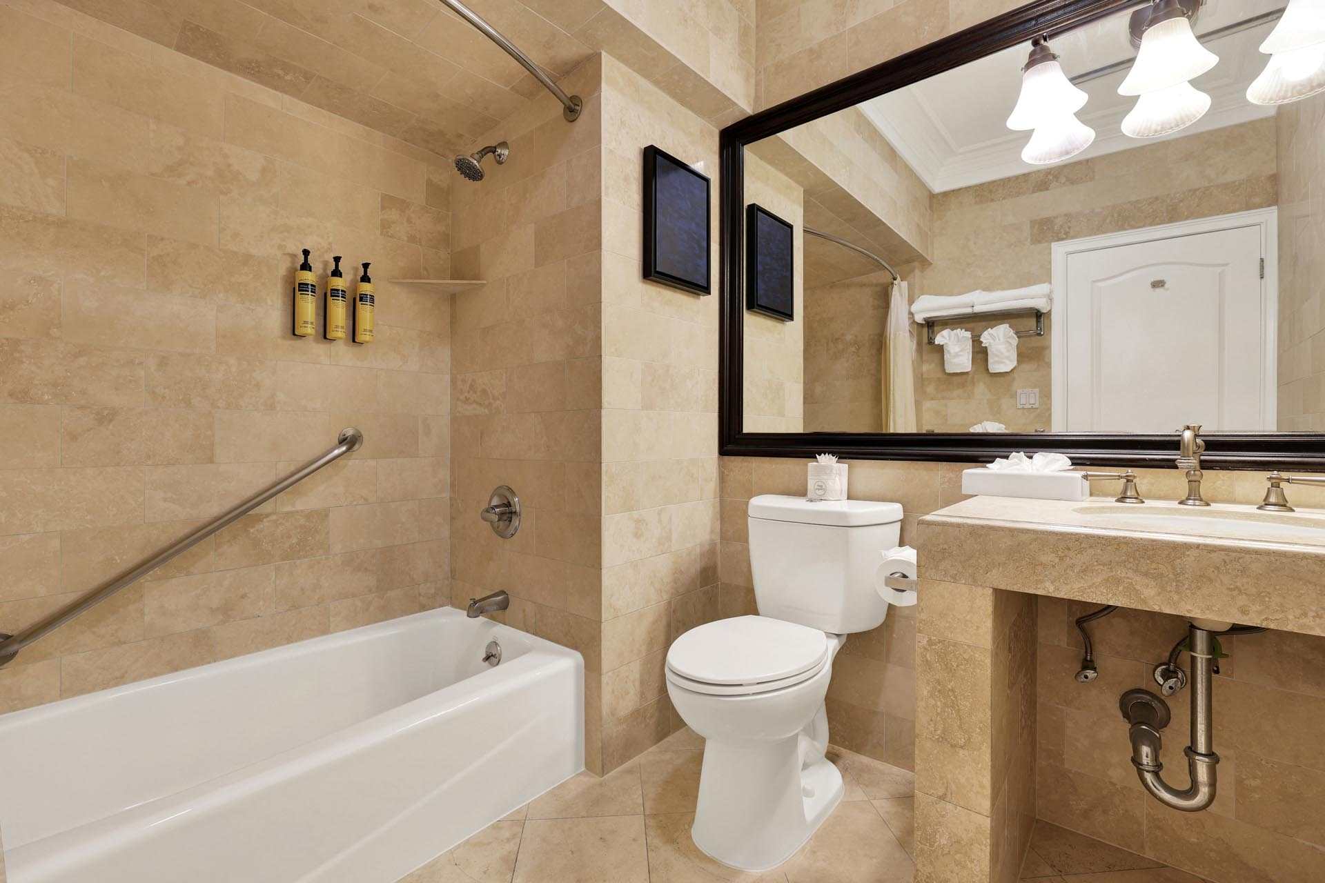 A bathroom with a tub, toilet, and a sink