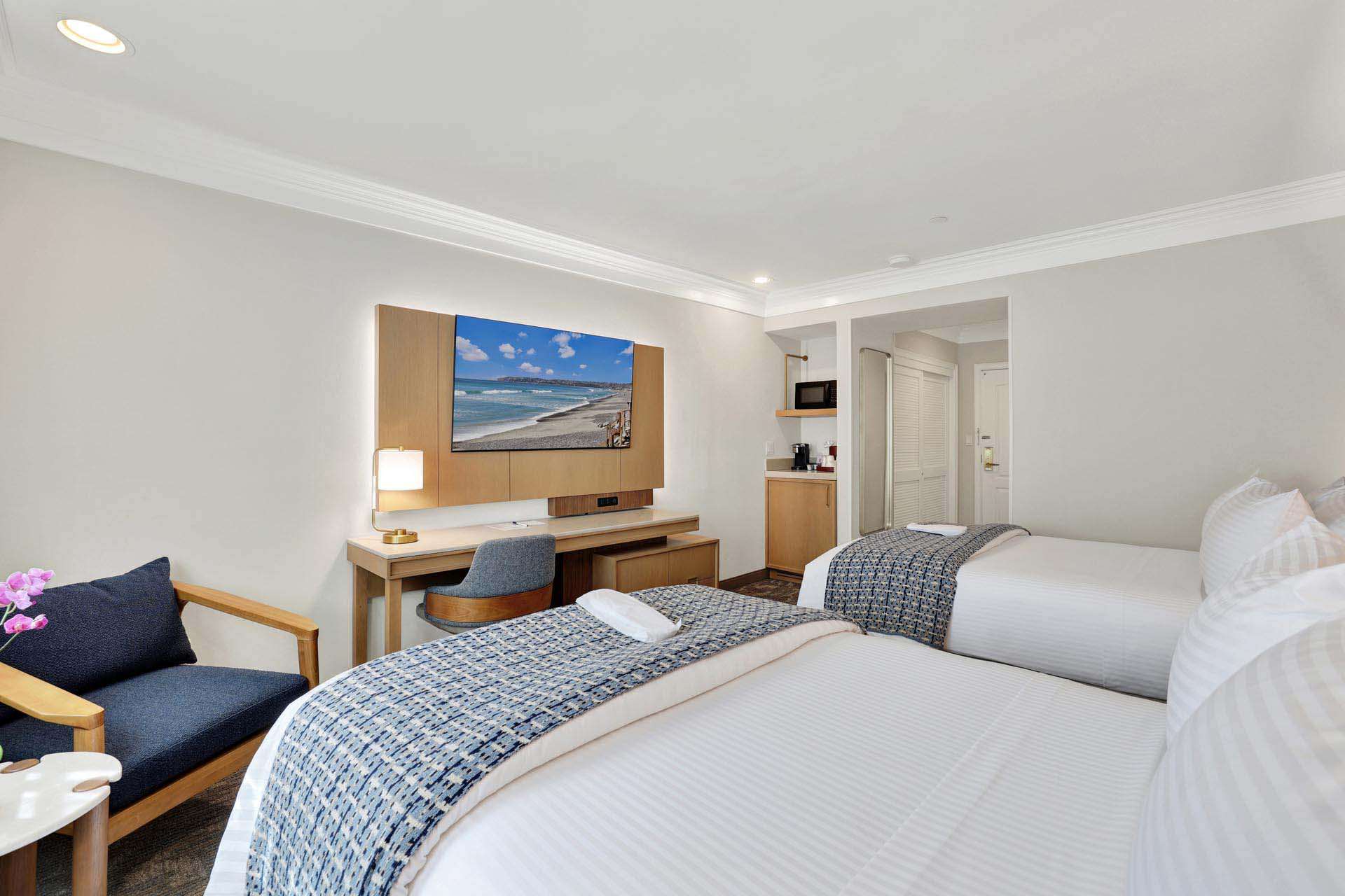 Two double beds, a desk, and an armchair